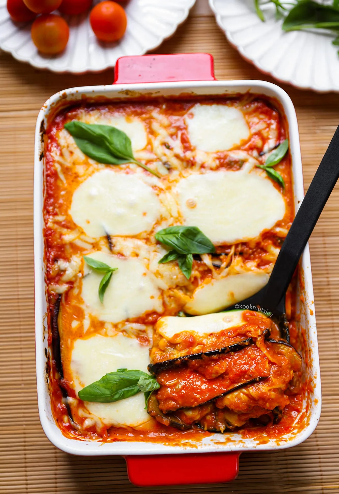 Aangesneden melanzane parmigiana met zichtbare lagen aubergine en kaas