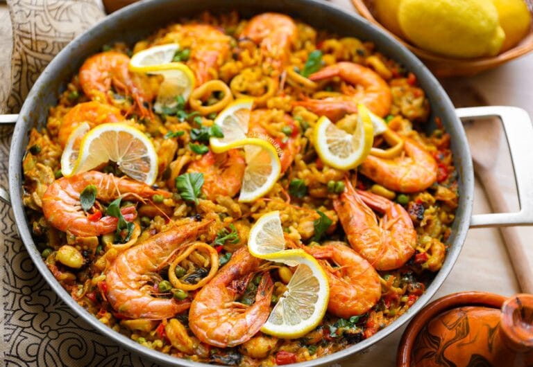 Paella met kip, garnalen en zeevruchten in een grote pan met saffraan en groenten