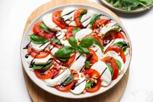 Salade caprese met tomaat, mozzarella, verse basilicum, pijnboompitten en balsamico