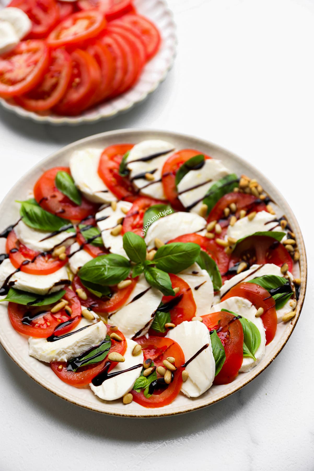 Kant-en-klare salade caprese met tomaat, mozzarella, basilicum en pijnboompitten