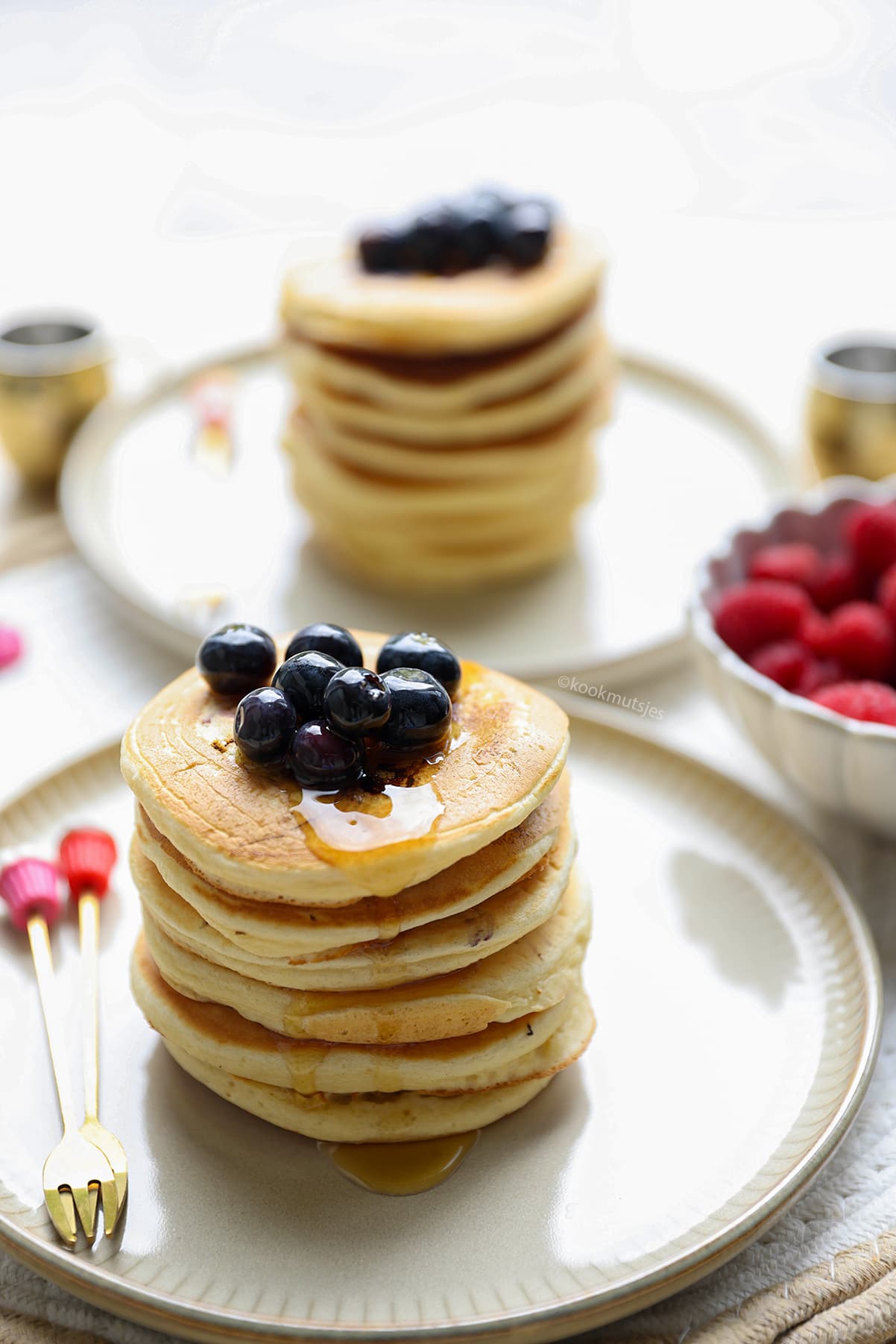 Stapel verse blueberry pancakes met ahornsiroop en bosbessen erop