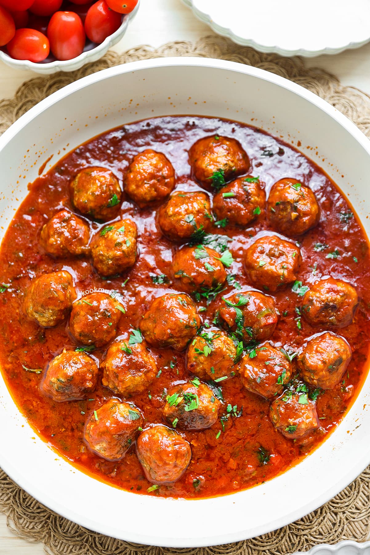 Albondigas in tomatensaus, geserveerd met vers brood en verse peterselie.