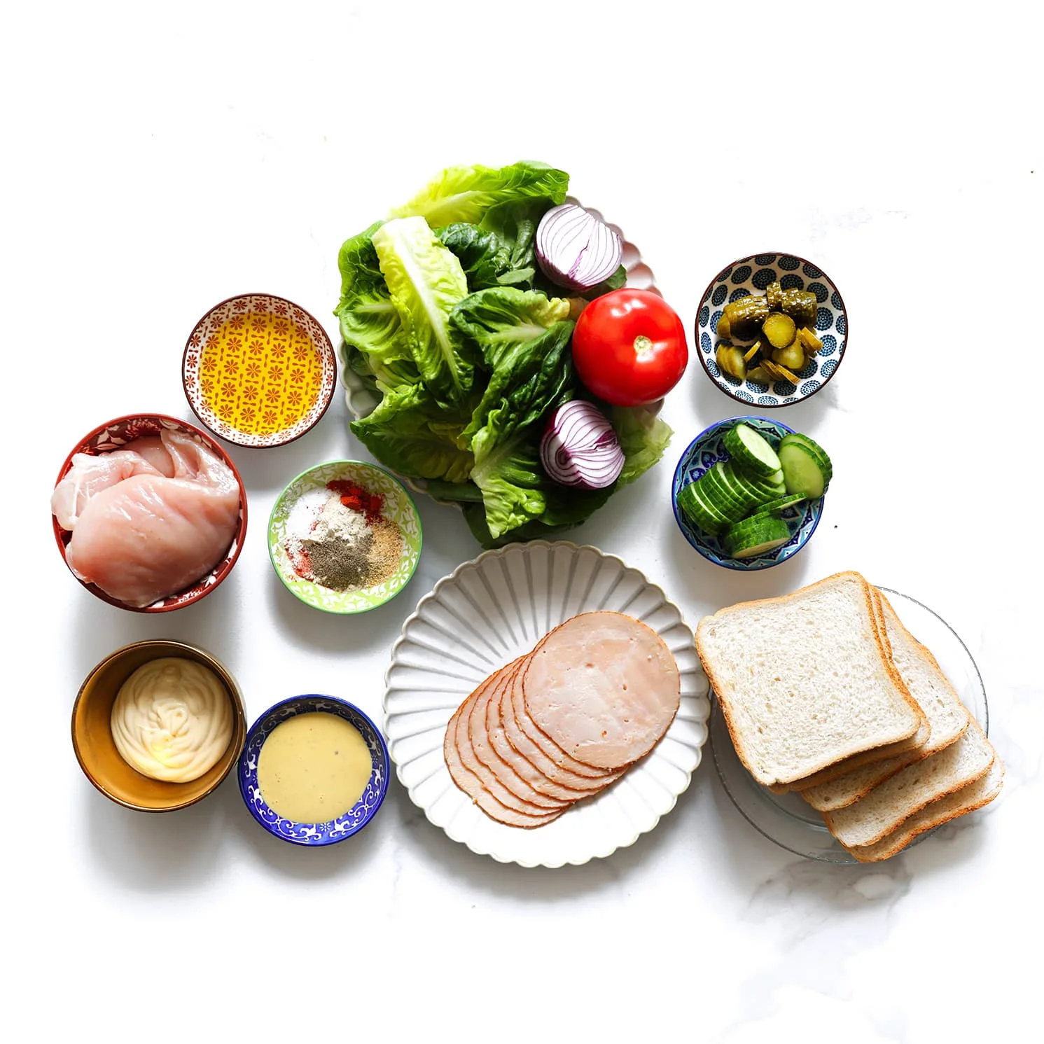 Ingrediënten voor een club sandwich met kip, kipsalami, kaas, groenten en mosterdsaus