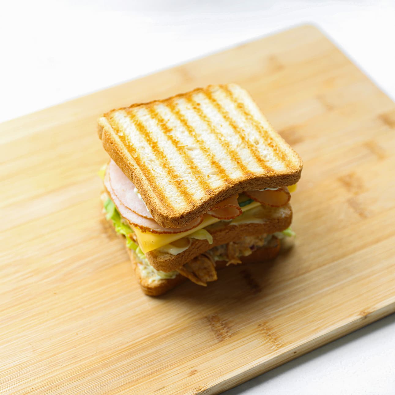Zelfgemaakte club sandwich met kip diagonaal doorgesneden en geserveerd