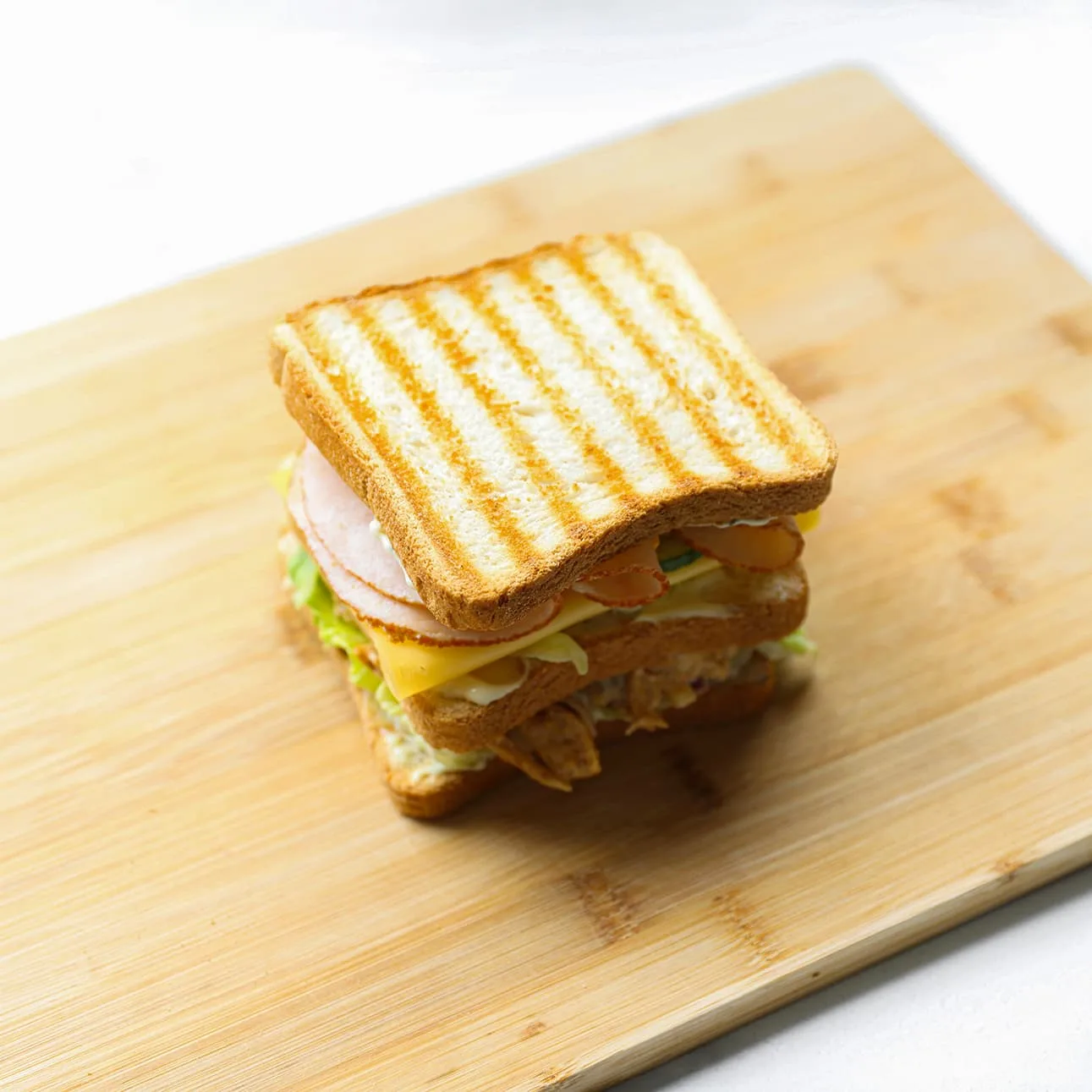 Zelfgemaakte club sandwich met kip diagonaal doorgesneden en geserveerd