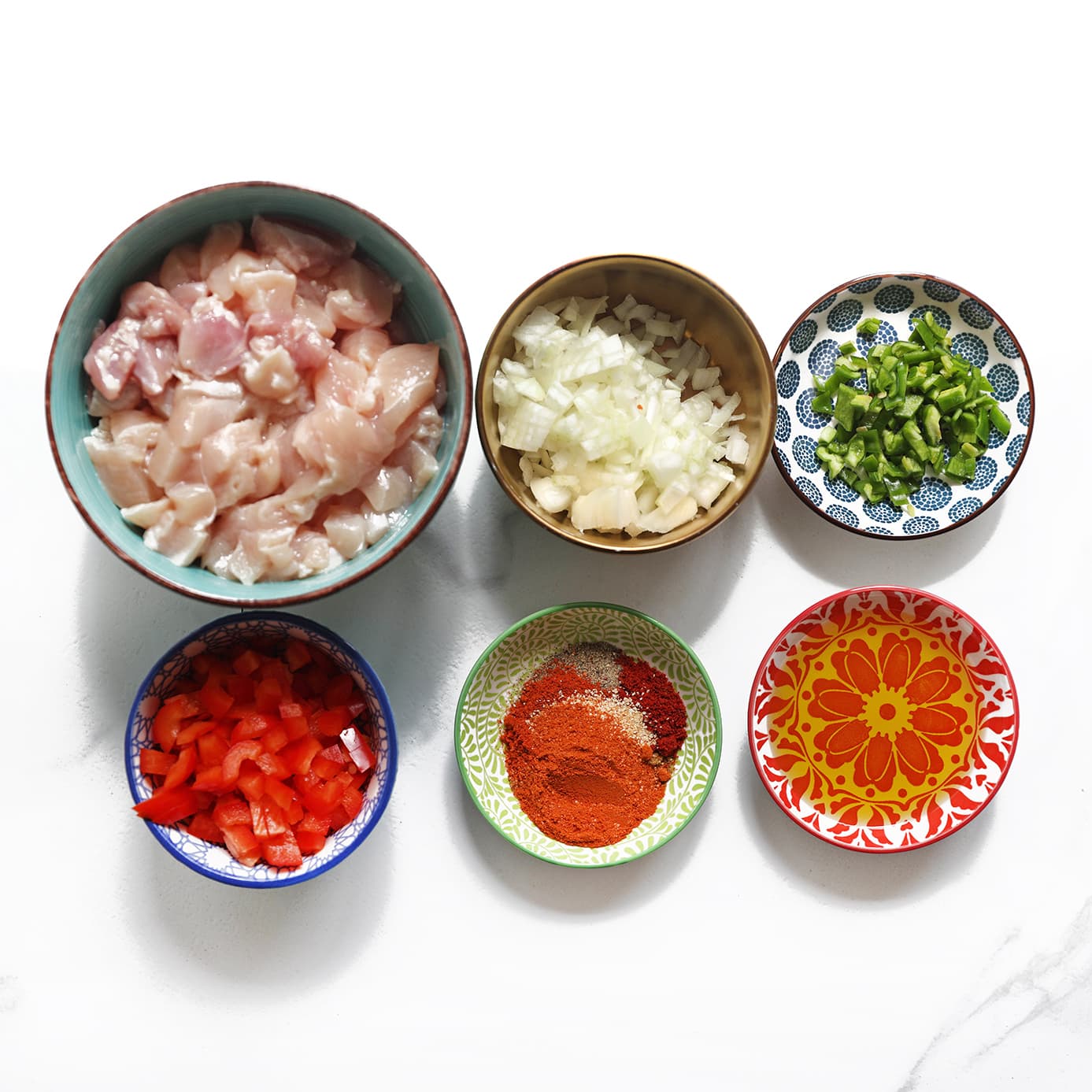 Alle ingrediënten voor het kipmengsel liggen klaar op het werkblad.