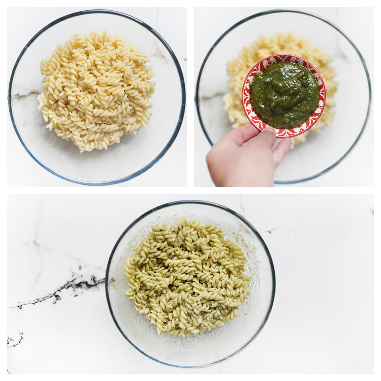 Gekookte fusilli wordt gemengd met groene pesto in een grote kom.