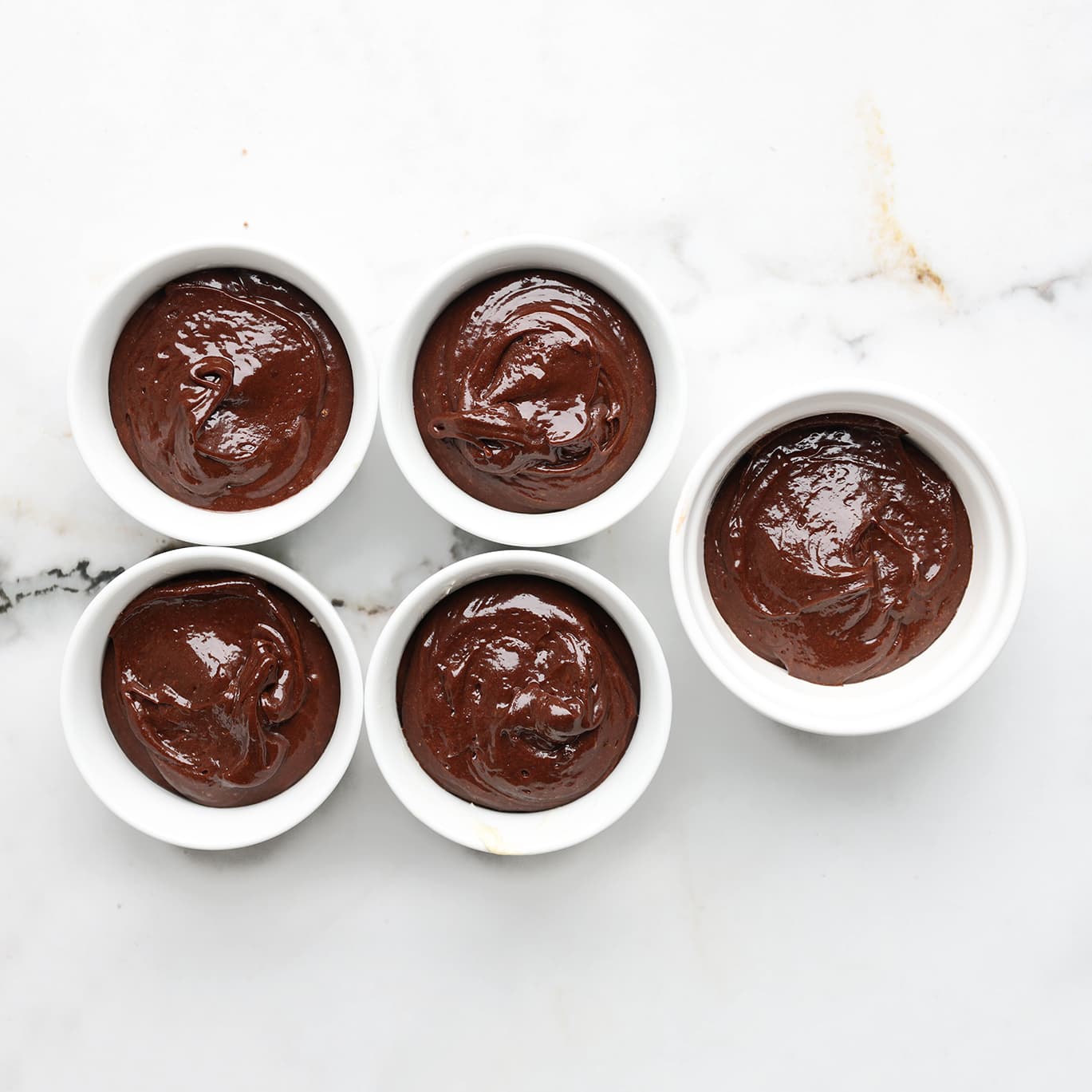 Chocolade lava cake beslag verdeeld over kleine ovenvormpjes