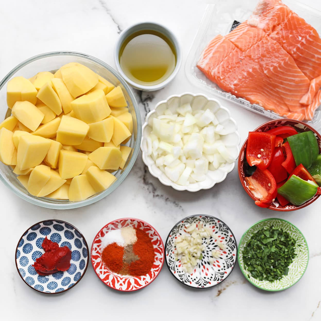 Ingrediënten voor zalm traybake met aardappels, paprika en kruiden