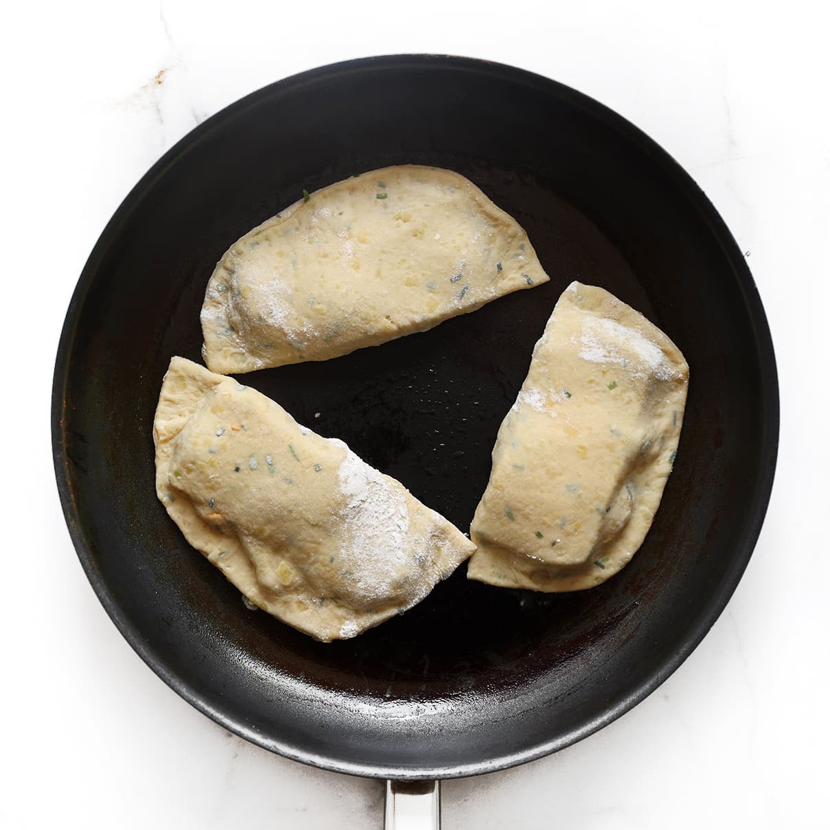 Aardappel tonijn broodjes goudbruin bakken in een koekenpan