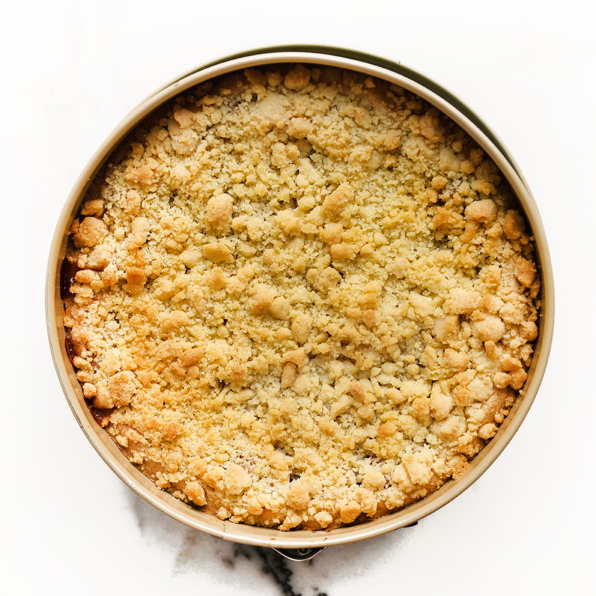 Versgebakken appelkruimeltaart met goudbruine kruimellaag in een springvorm
