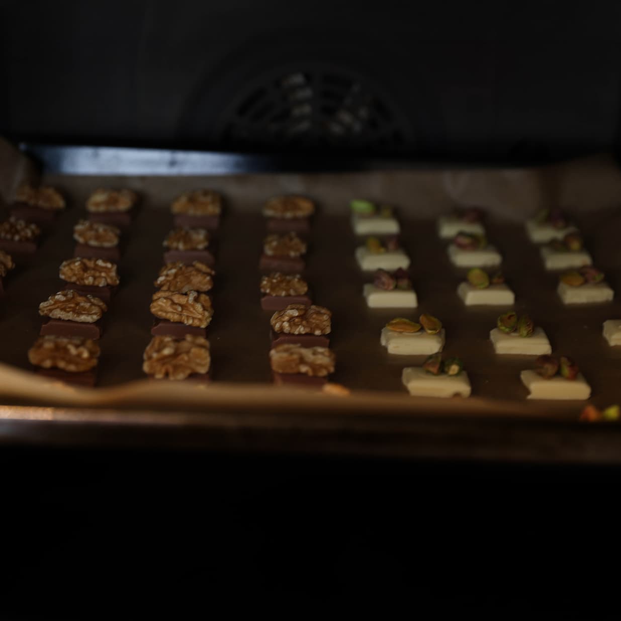 Chocoladeblokjes met noten op een bakplaat in de oven om zacht te worden.
