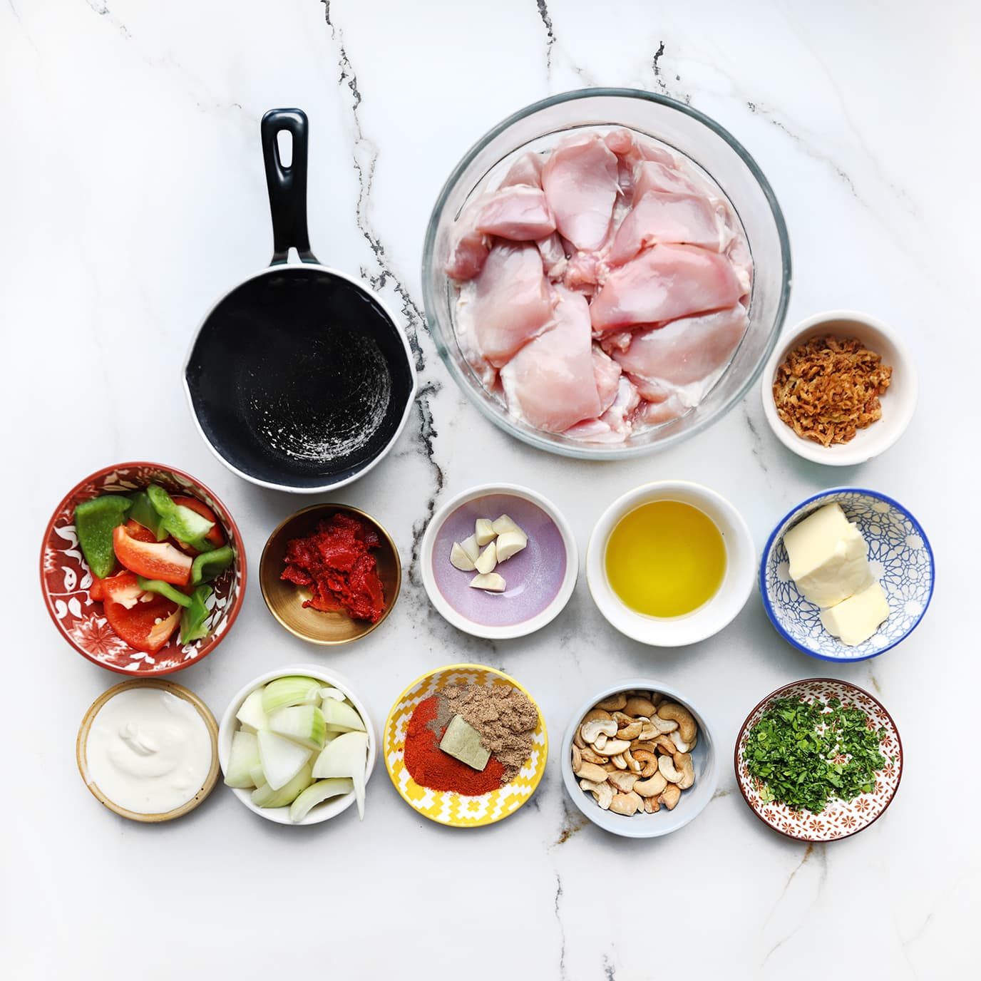 Ingrediënten voor kip kabsa met ui, tomaat, knoflook, paprika en cashewnoten