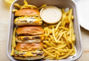 Smashburger met cheddar, burgersaus, augurk en ui op een hamburgerbroodje