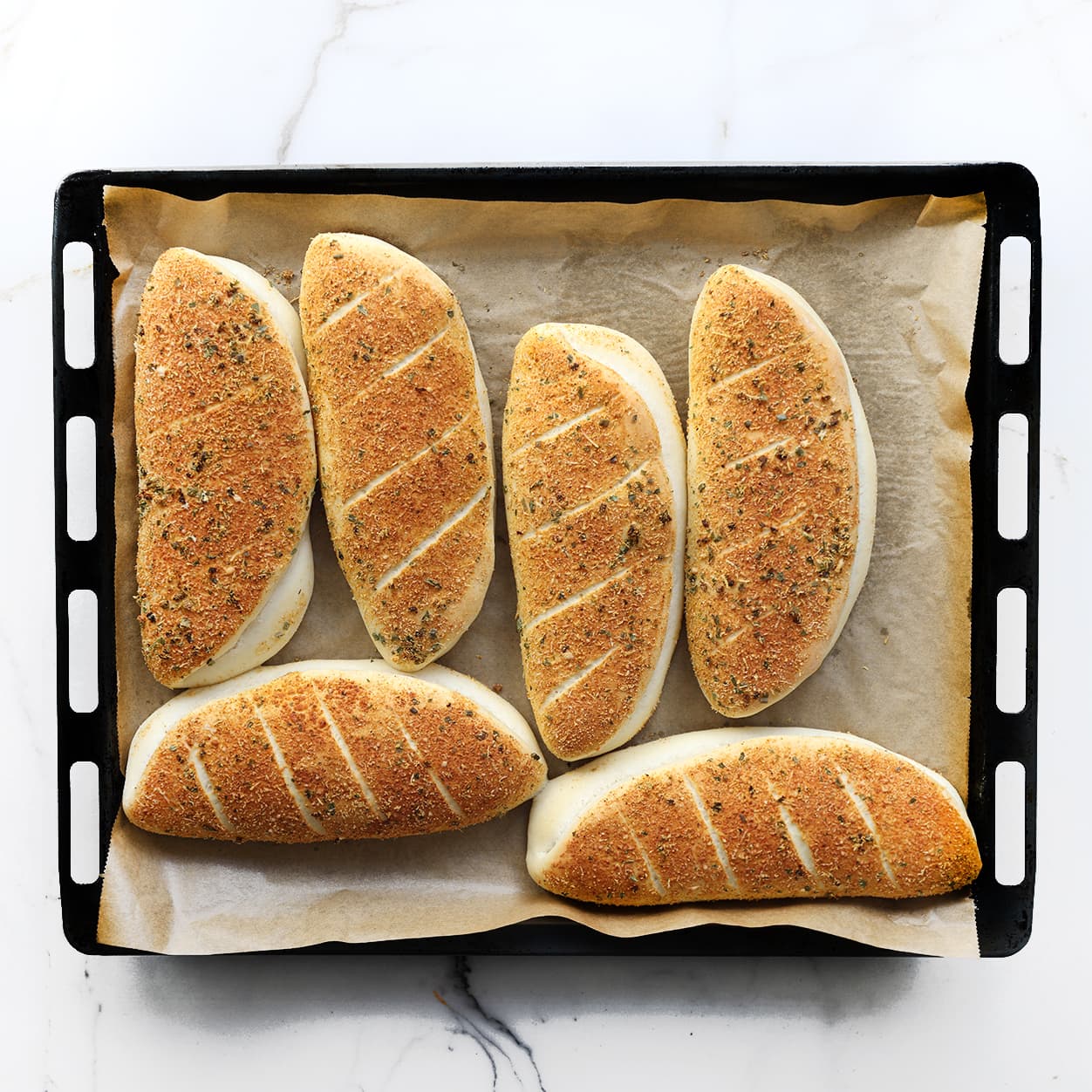 Goudbruine zelfgemaakte Subway broodjes met een laagje Parmezaanse kaas