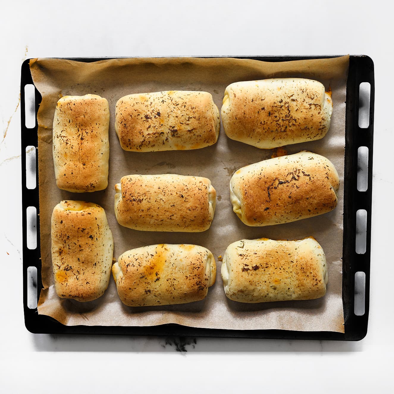 Versgebakken chicken tikka masala broodjes met een goudbruine buitenkant op een bakplaat