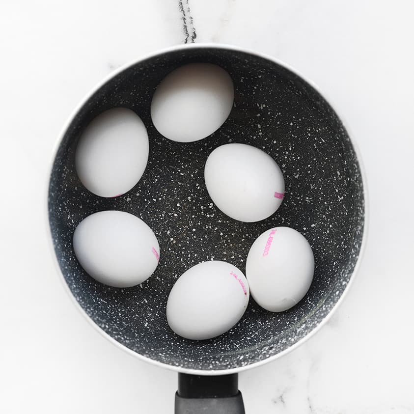 Eieren koken in een pan met kokend water voor gevulde eieren