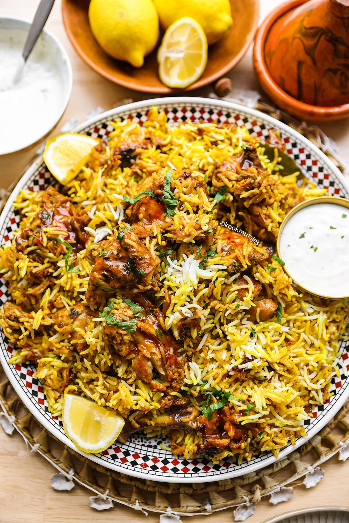 Close-up van kip biryani met gele saffraanrijst, malse kip en gebakken ui