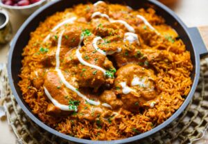 Close-up van romige kip kabsa met malse kip en rijst gekookt in kruidige saus