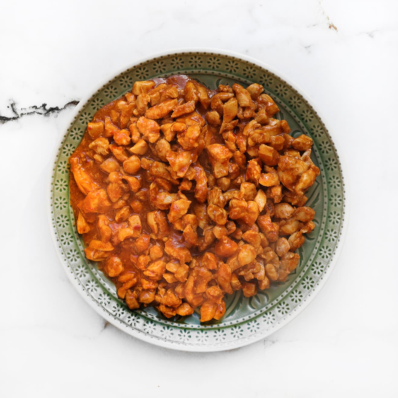 Gekruide kip met zoet-pittige saus in een kom om af te koelen